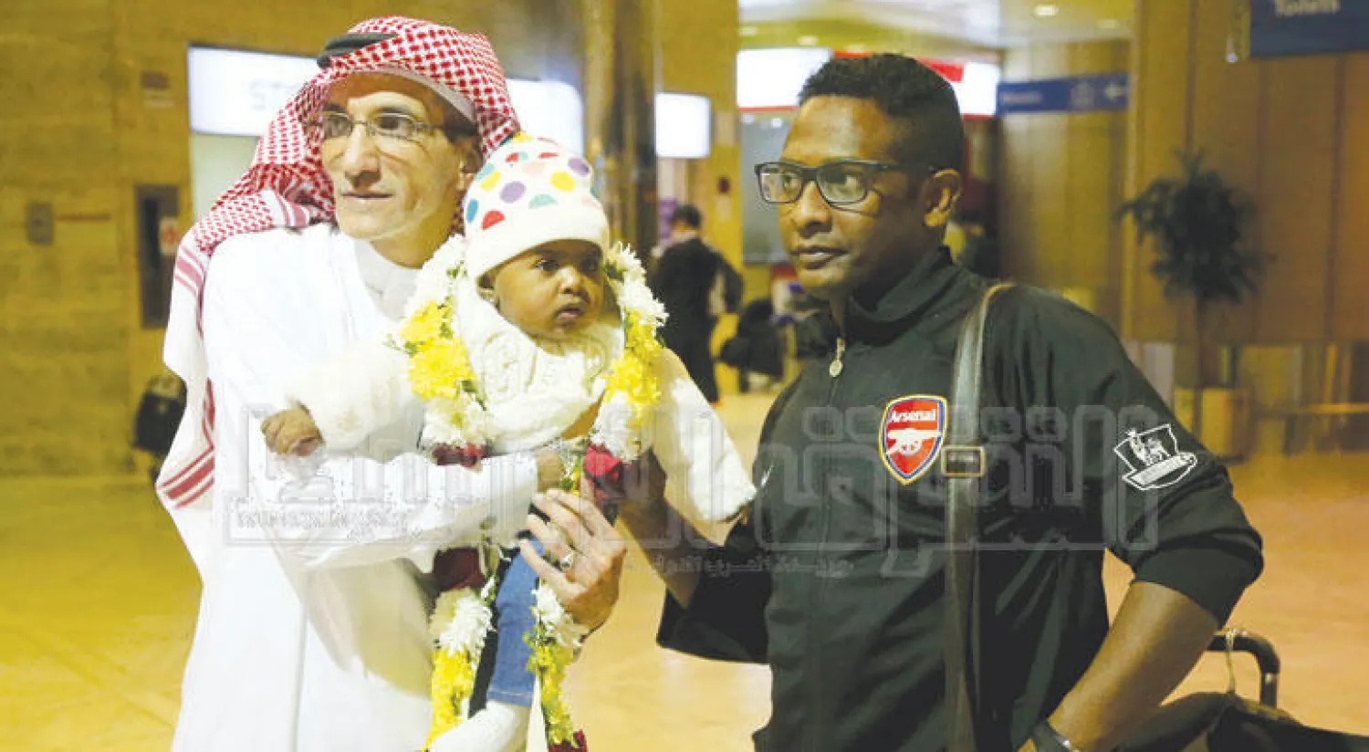 يوسف العبدان مدير مطار الملك خالد الدولي بالرياض يحمل ابن أحد أعضاء البعثة الدبلوماسية السعودية العائدين من إيران أمس غداة قرار الحكومة السعودية بقطع العلاقات مع طهران (تصوير: مشعل القدير)