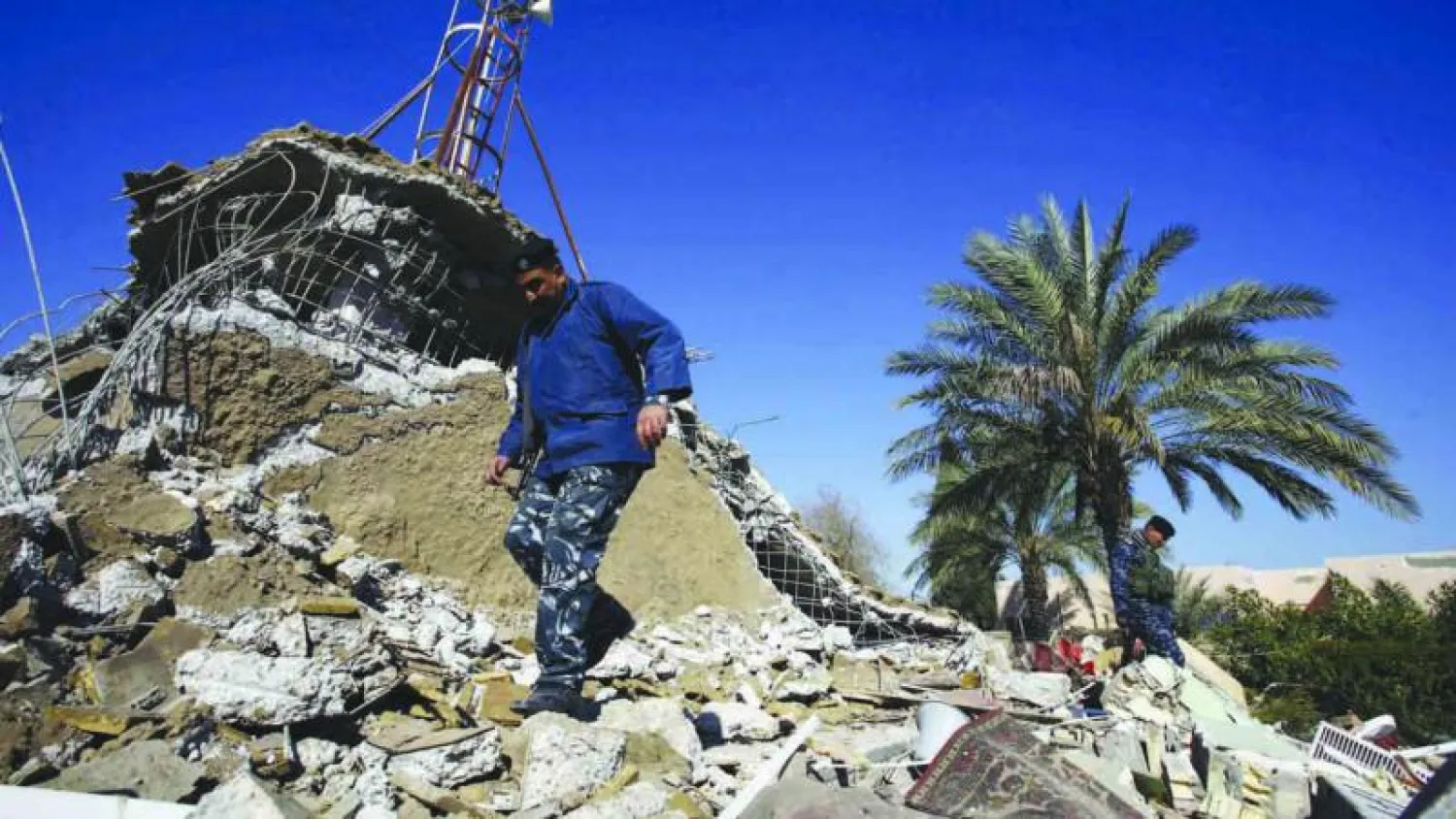 شرطي يعاين أنقاض مسجد الفتح المبين الذي كان واحدا من ثلاثة مساجد سنية فجرت في محافظة بابل الليلة قبل الماضية (أ.ف.ب)
