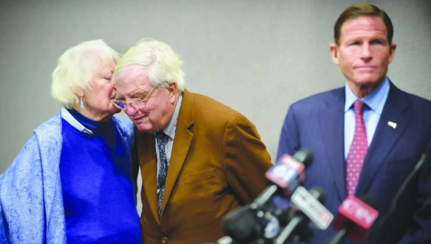 الرهينة الاميركي السابق في طهران مورهيد كنيدي يستمع الى زوجته خلال مؤتمر صحافي امس في هارتفورد بالولايات المتحدة حيث أعلن عن صفقة تعويضات ايرانية للرهائن السابقين (أ.ب)