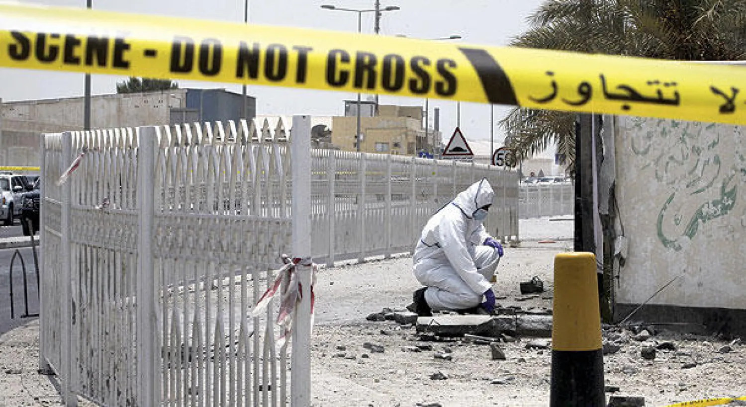 شرطي من المباحث الجنائية البحرينية لدى معاينته آثار تفجير قنبلة في جزيرة سترة جنوب البحرين اودى بحياة اثنين في يوليو 2015 (غيتي)