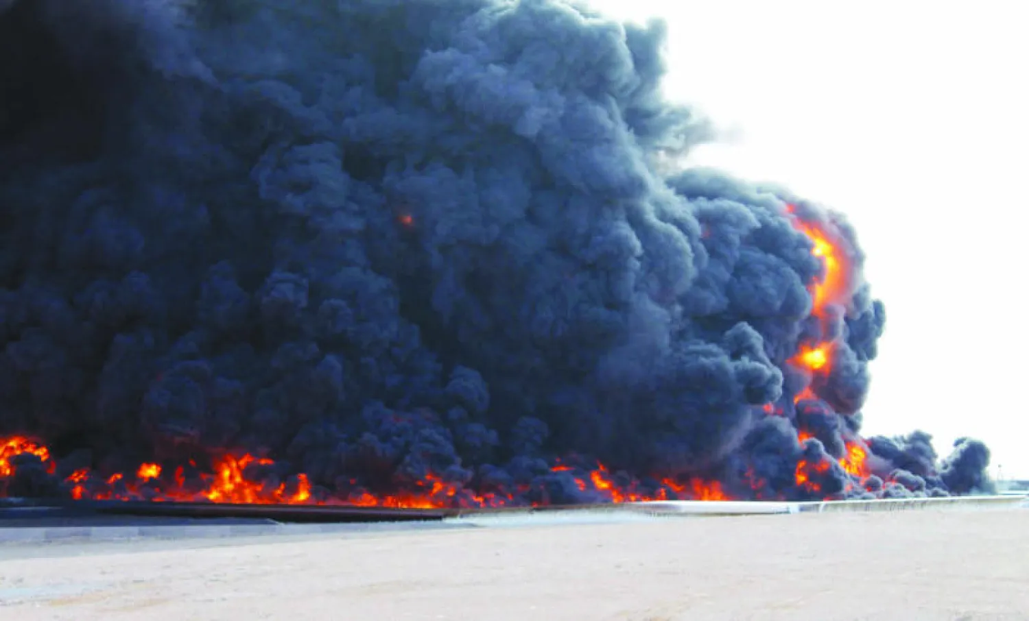 صورة تعود إلى ديسمبر 2014 لميناء سدرة النفطي وقد اشتعلت به النيران عقب تعرضه لهجمات من عناصر الميليشيات المسلحة (إ.ب.أ)