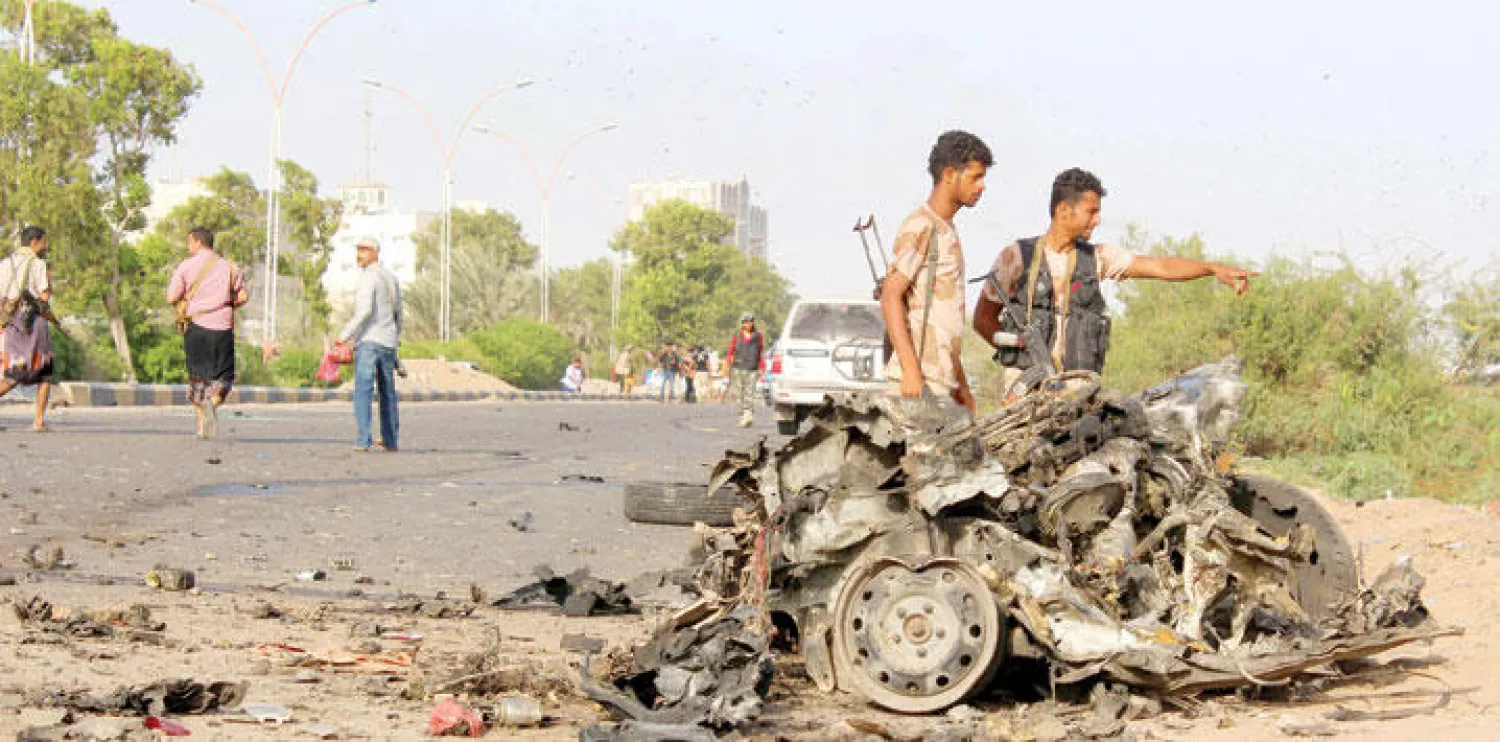 ما تبقى من السيارة المفخخة التي استهدفت الموكب الرسمي في عدن (أ.ف.ب)