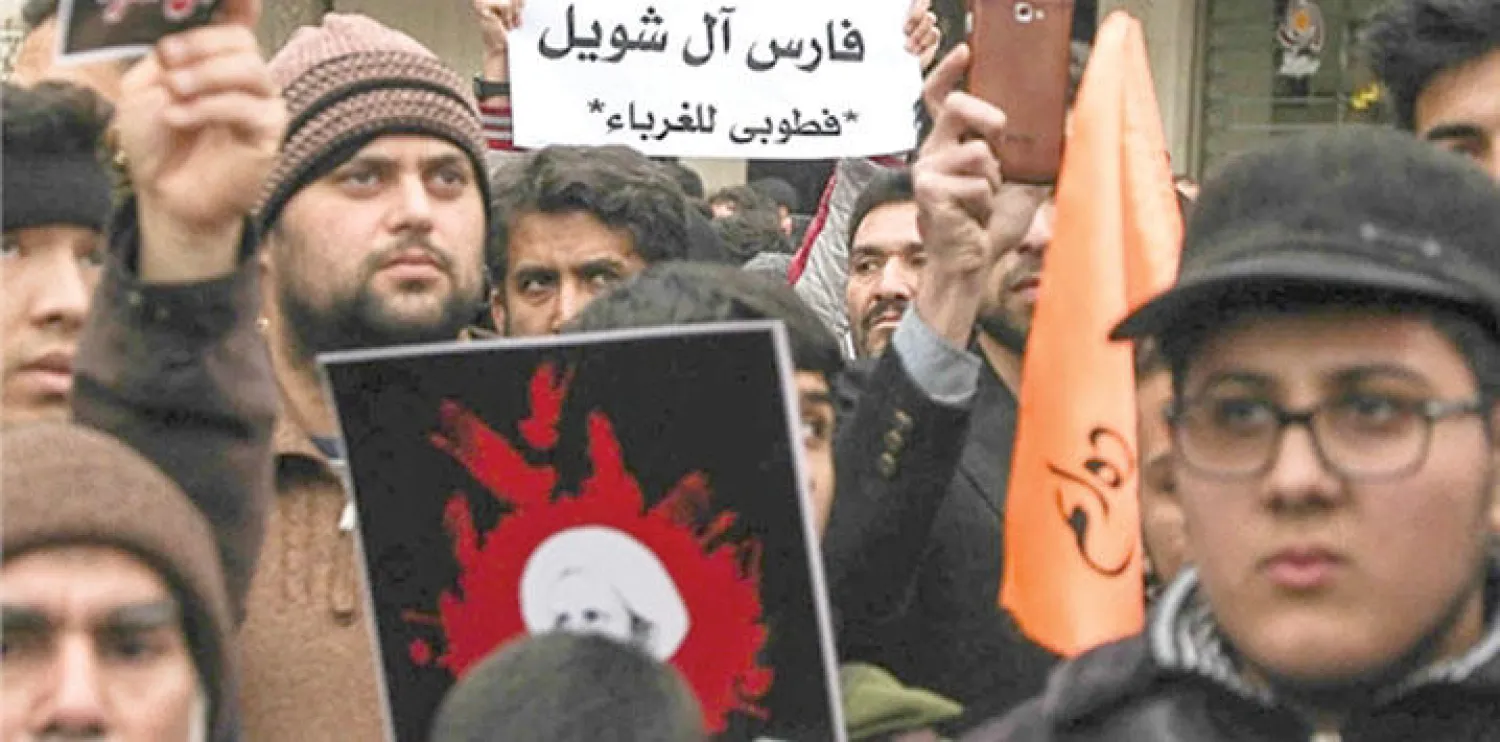 عناصر من الباسيج يحملون صورا لمنظر «القاعدة» فارس آل شويل ونمر النمر في مظاهرة تأييد للمحكومين بالإرهاب (وكالة {فارسي} الإيرانية)