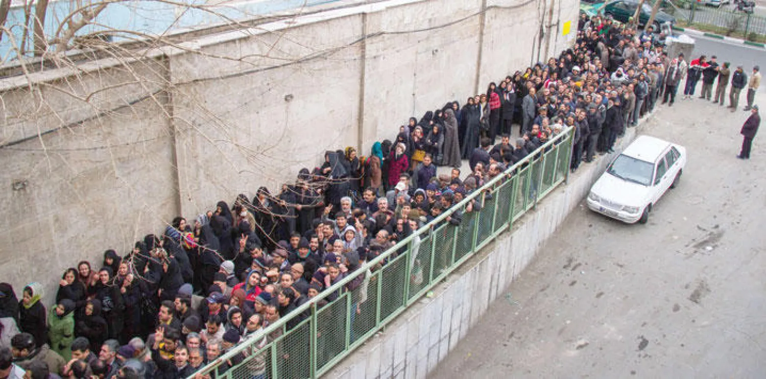 صورة أرشيفية لإيرانيين ينتظرون الحصول على حصتهم الغذائية جنوب طهران في فبراير (شباط) 2014 (أ. ف. ب)