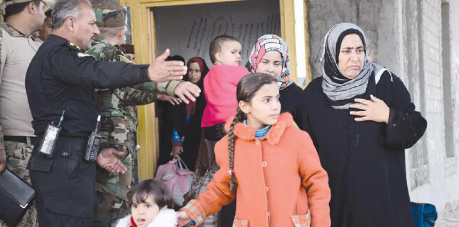 أفراد عائلة عراقية أثناء إجلائهم من الرمادي أول من أمس (إ.ب.أ)