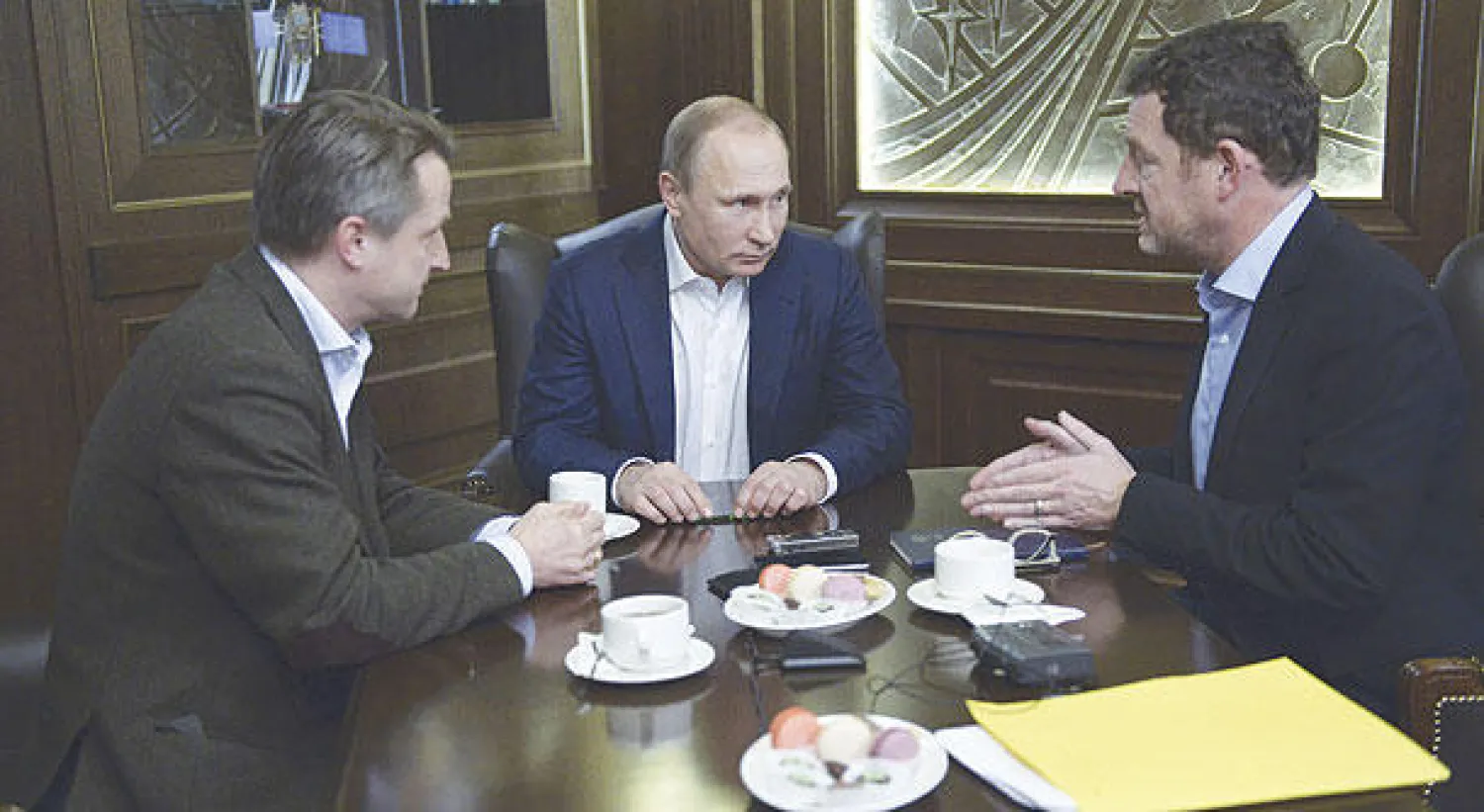 بوتين لدى إجرائه مقابلة مع رئيس تحرير صحيفة {بيلد} الألمانية ونائبه في منتجع سوتشي الروسي (رويتز)