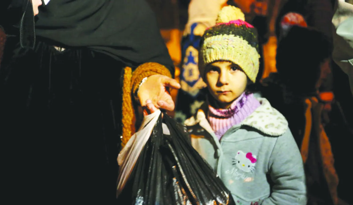 طفلة سورية تنتظر مع عائلتها وصول الإذن من النظام السوري لمغادرة مضايا أمس (رويترز)