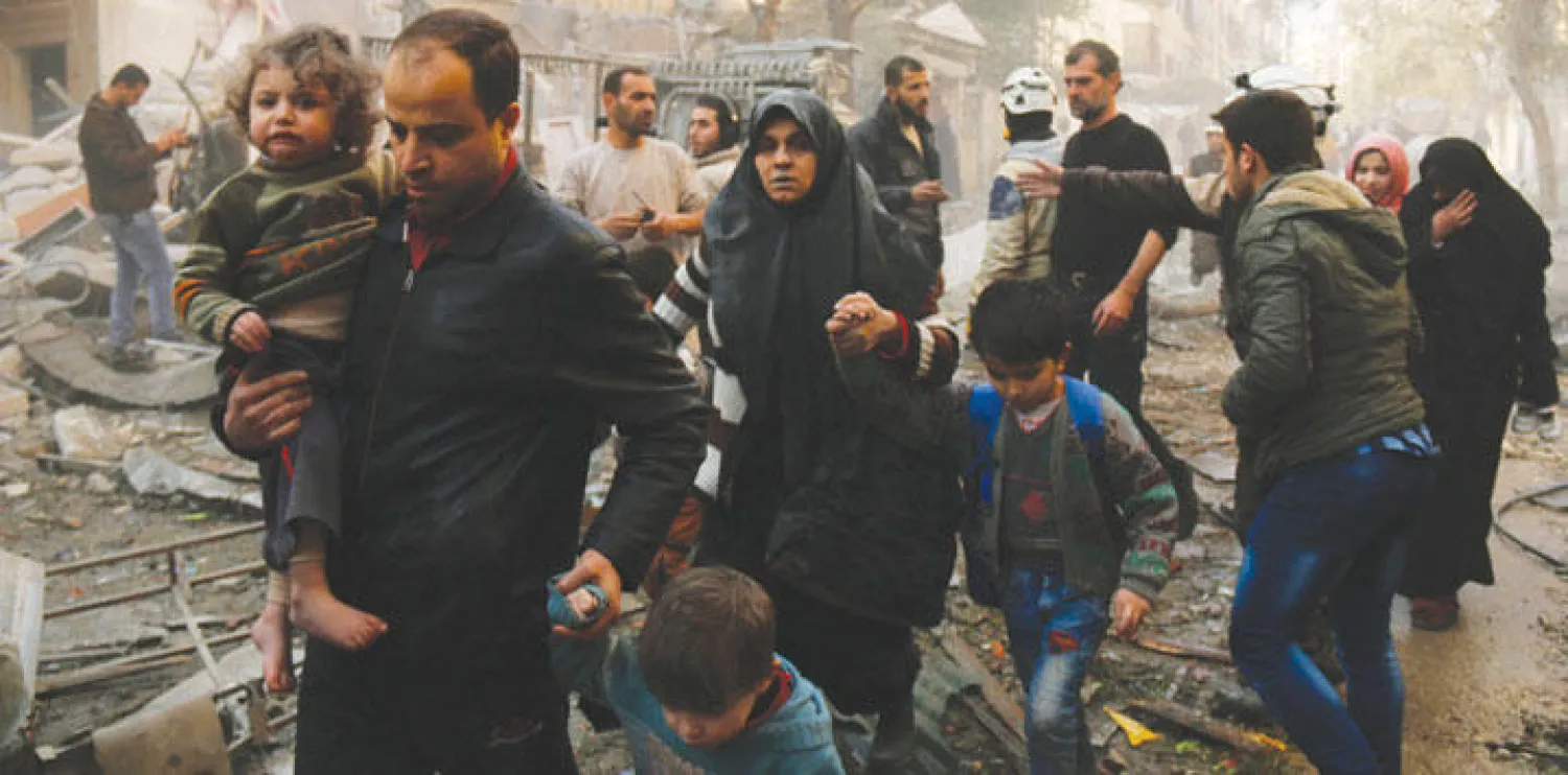 مدنيون من سكان منطقة في حلب يهرعون باتجاه أخرى أكثر أمنا تحت قصف الطيران الحربي أول من أمس (أ.ف.ب)