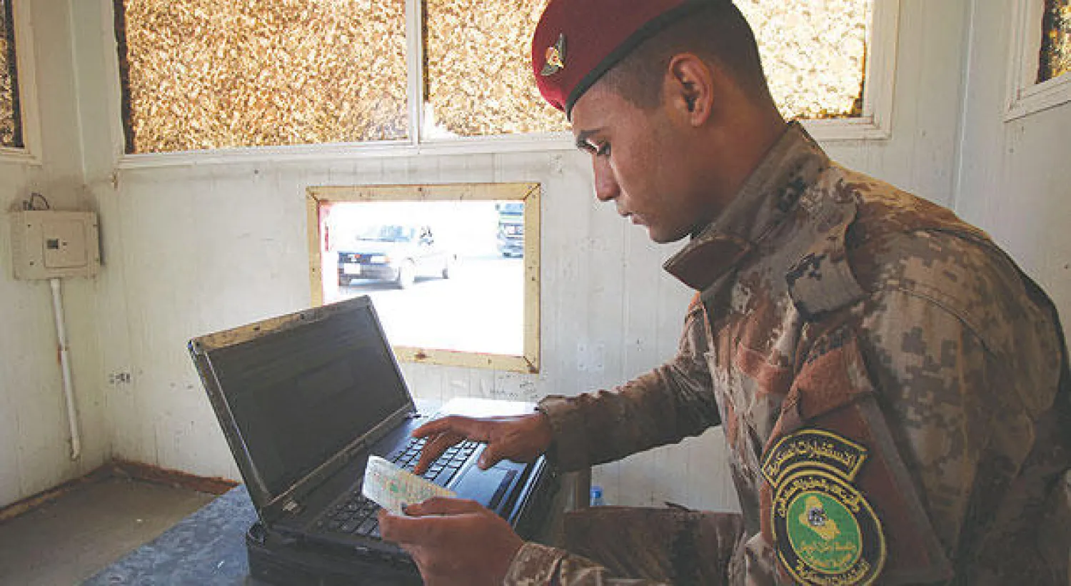 جندي في الجيش العراقي يتحقق من بيانات مواطن عند نقطة تفتيش، في مدينة البصرة أمس،  ضمن خطة أمنية لمساعدة السلطات المحلية في بسط الأمن بالمدينة الواقعة جنوب العراق (أ.ف.ب)