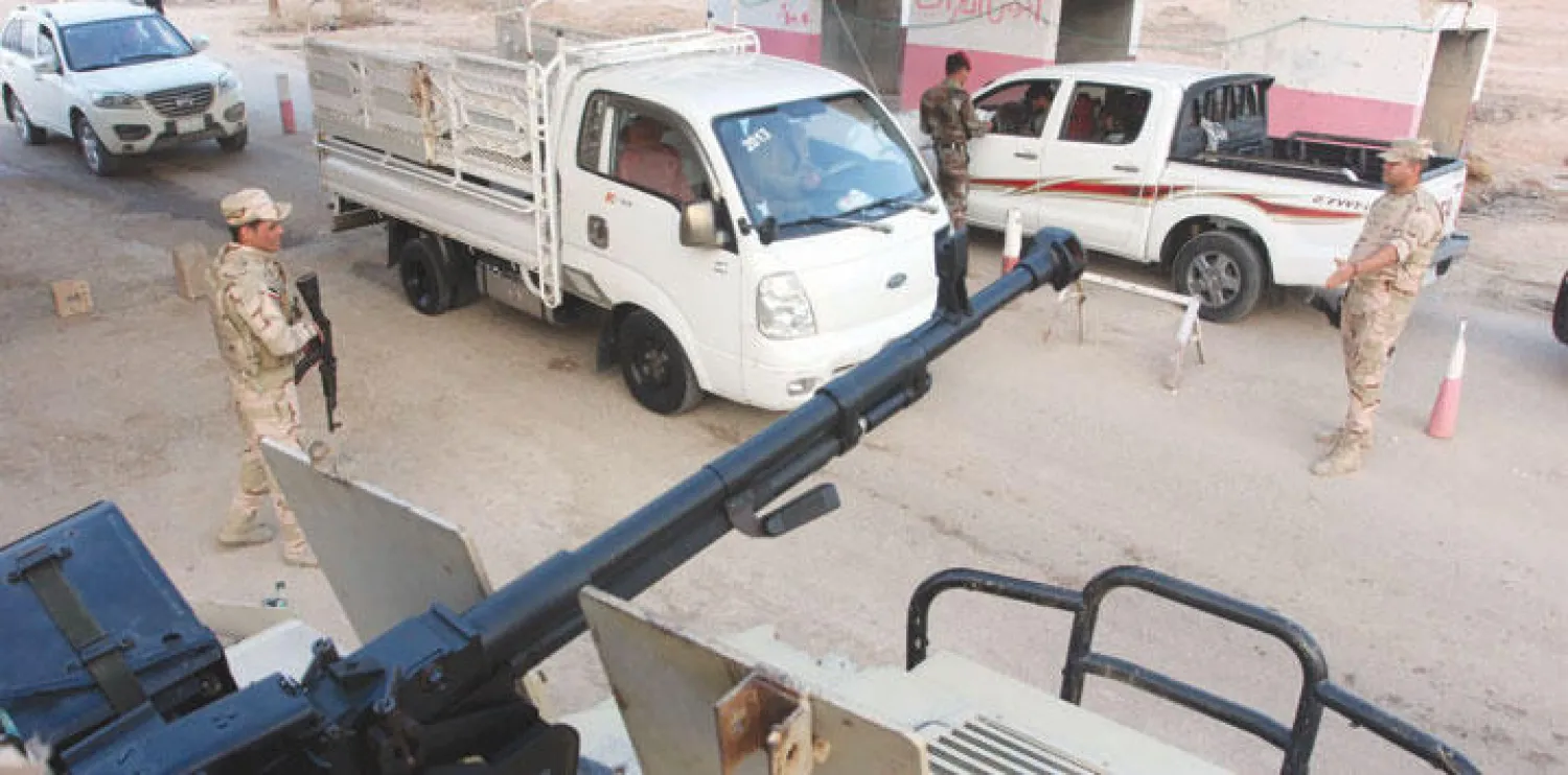 عناصر من قوات الأمن العراقية يفتشون سيارات في البصرة أمس (رويترز)