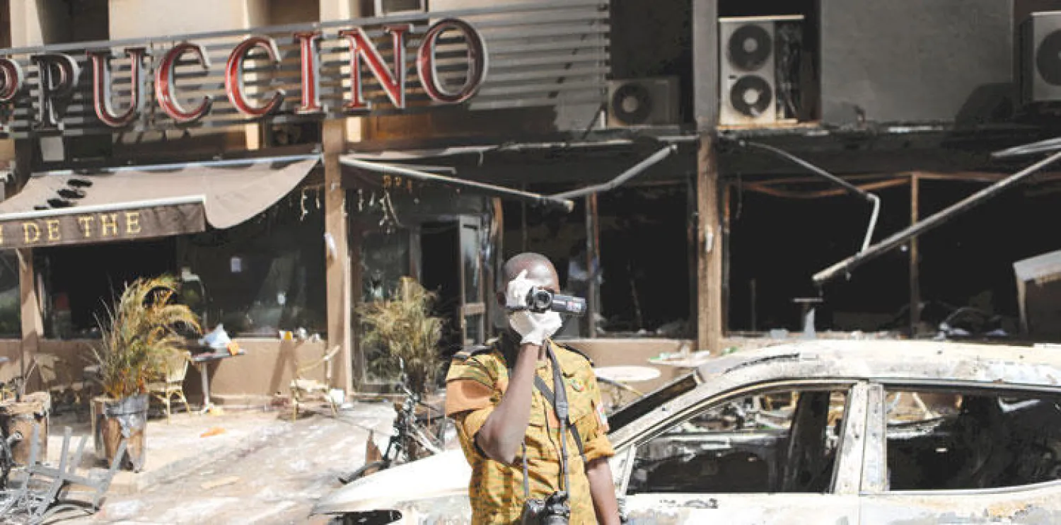 جندي بوركينابي يصور موقع الهجوم الإرهابي في العاصمة واغادوغو أمس (رويترز)