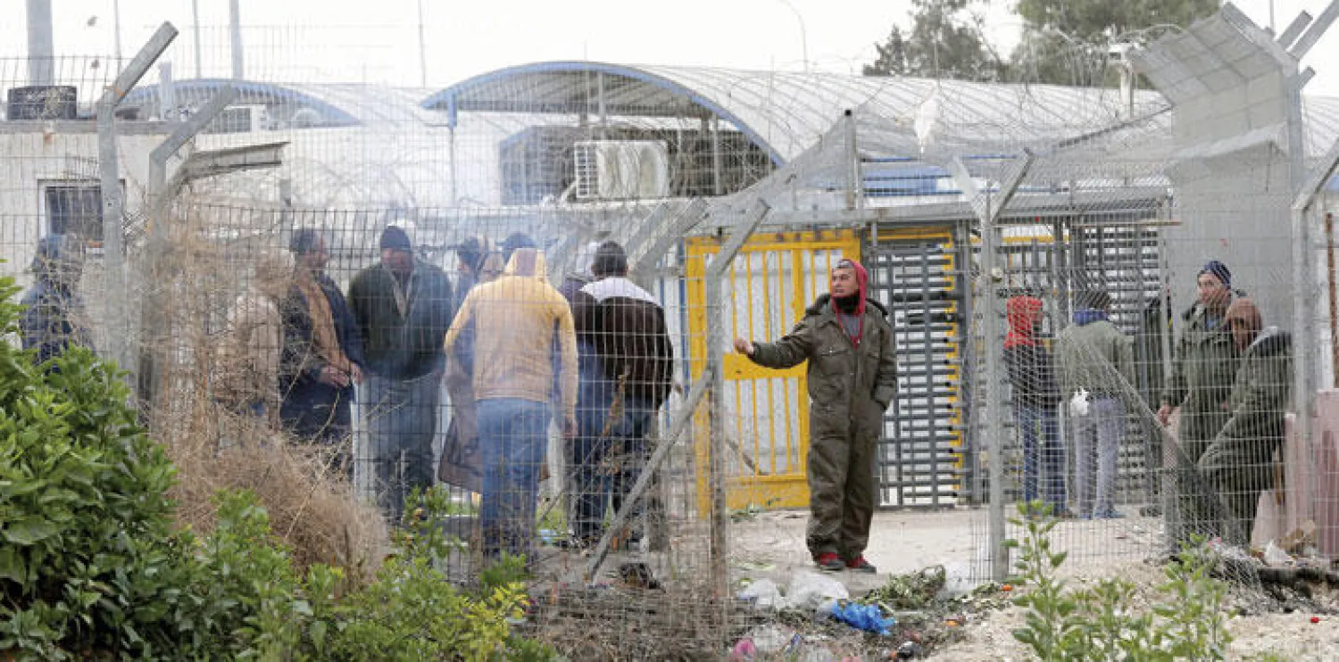صورة تعود الى 2014 لعمال فلسطينيين امام حاجز اسرائيلي في الضفة الغربية (إ.ب.أ)