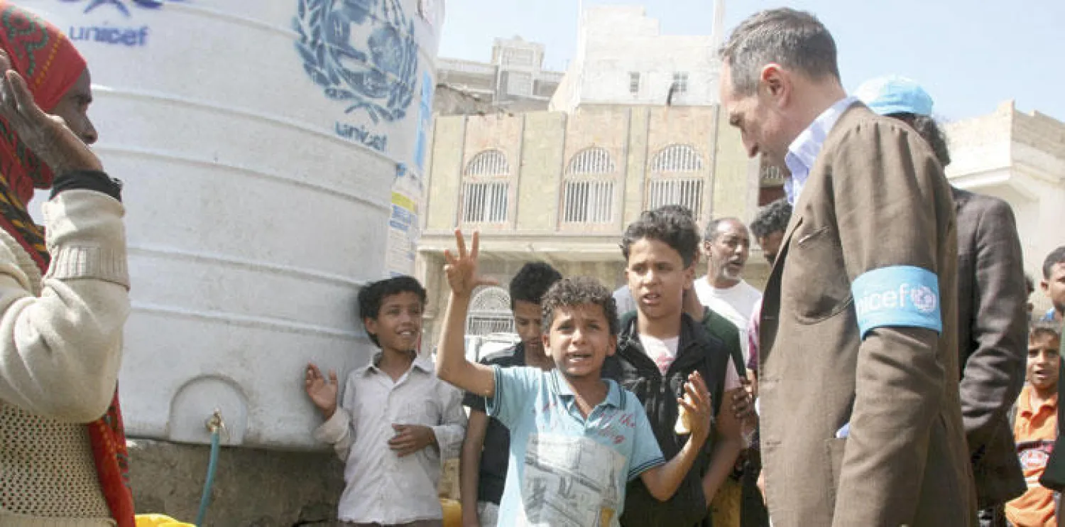 ممثل اليونيسيف جوليان هارنيس يستمع إلى أحد الأطفال في تعز المحاصرة (رويترز)