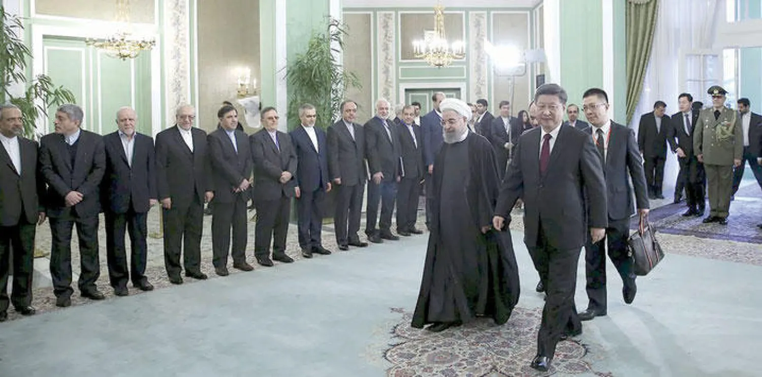 الرئيس الإيراني حسن روحاني مستقبلا الرئيس الصيني تشي جينغ بينغ في طهران أمس (رويترز)