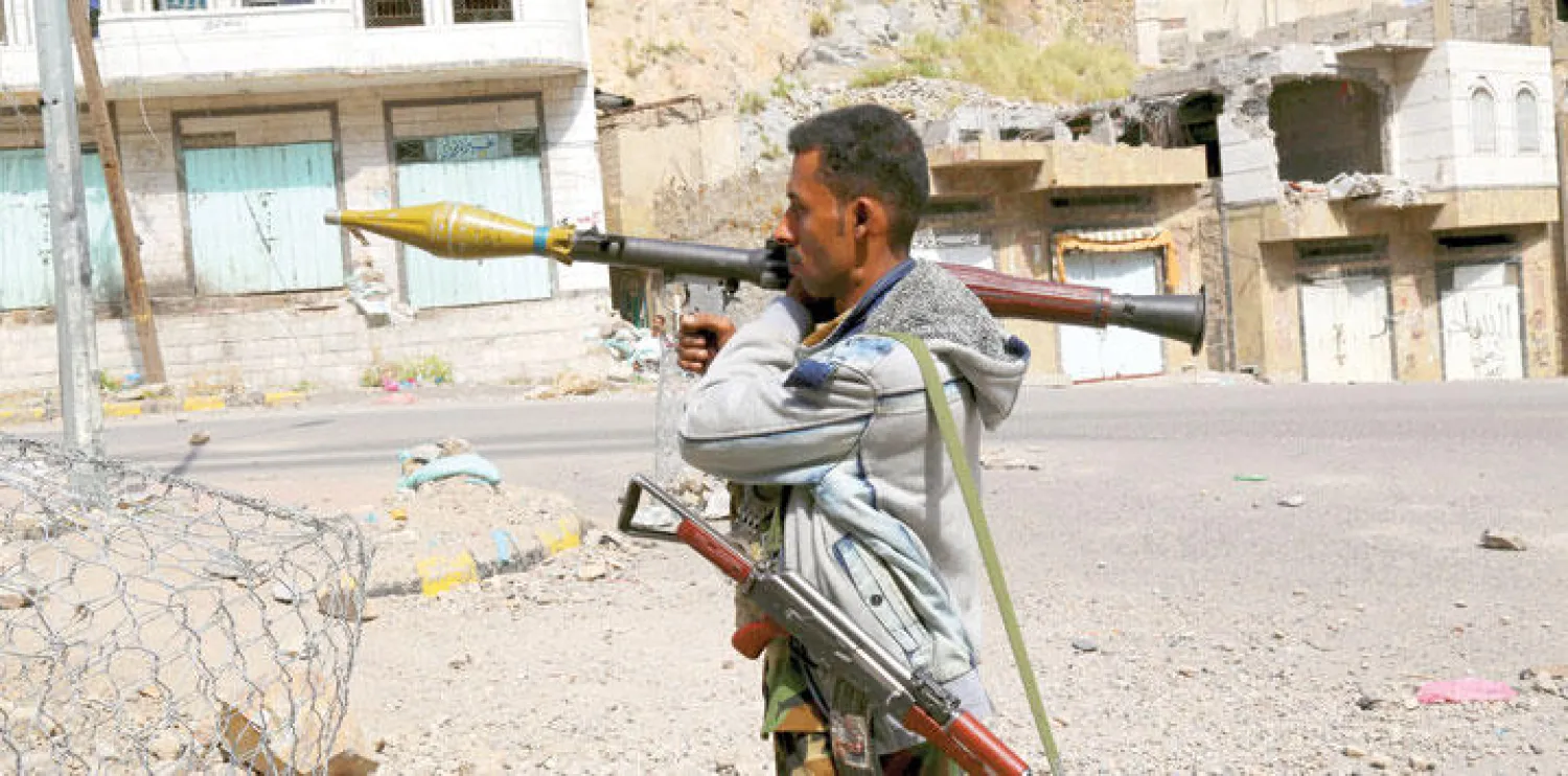 مقاتل من الموالين للشرعية أثناء حراسة أحد مداخل مدينة تعز (رويترز)