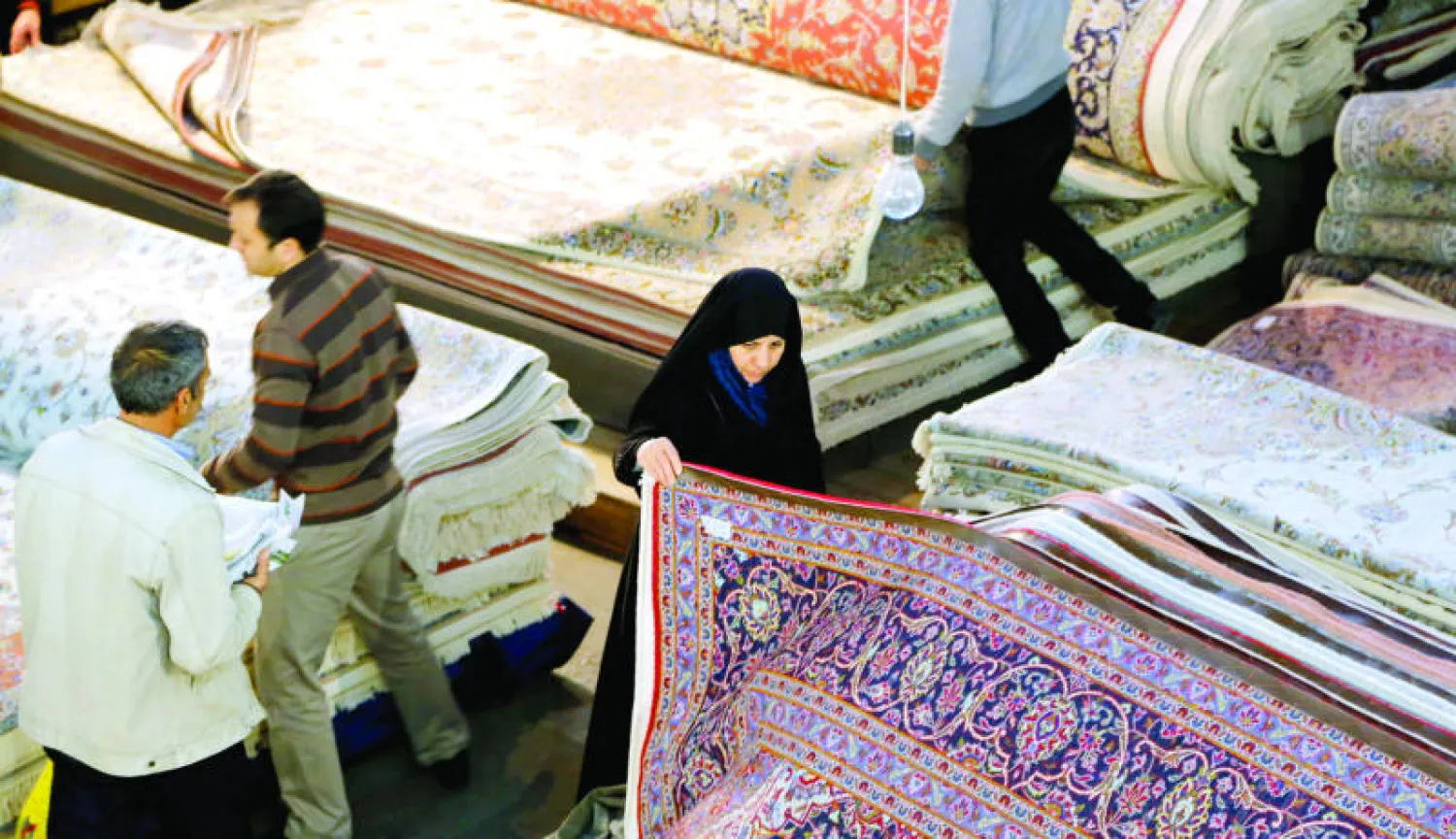 إيرانيون في أحد متاجر السجاد في طهران (إ.ب.أ)