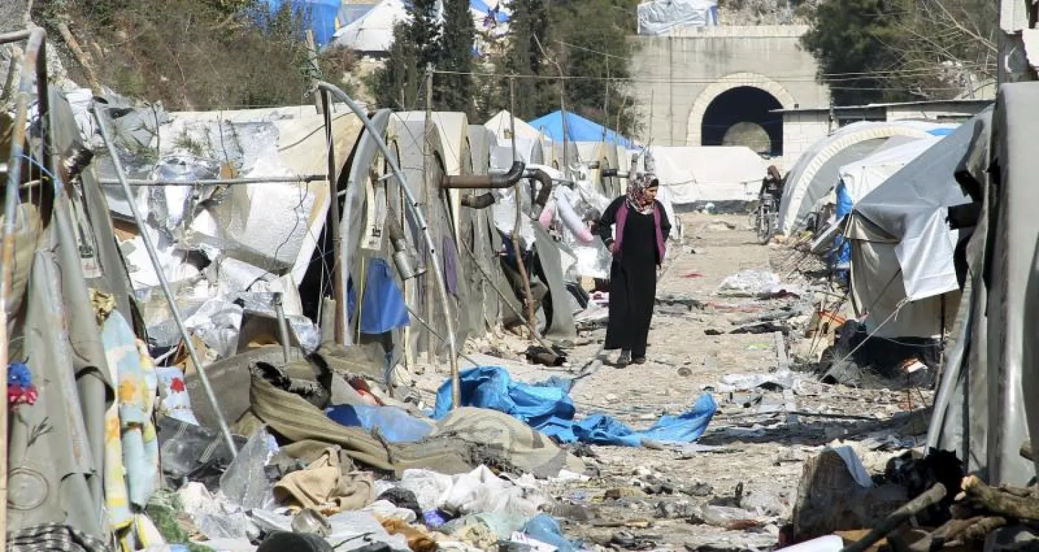 نازحة سورية تتفحص الدمار بعد غارة من طيران الأسد، أول من أمس، على مخيم سوري أنشئ لاستقبال النازحين من جبل التركمان قرب الحدود التركية (رويترز)