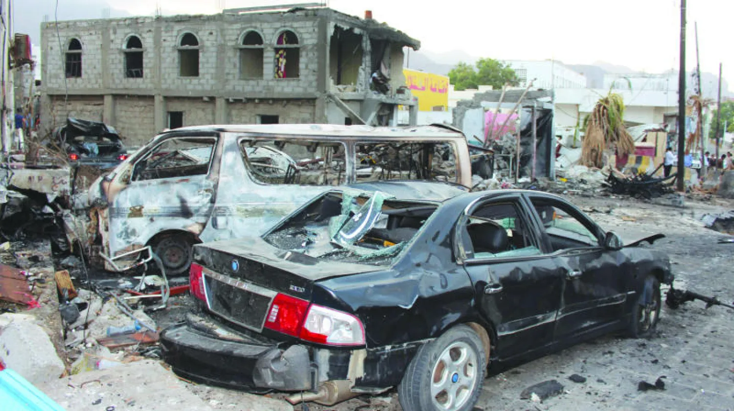 سيارات تعرضت للدمار خارج القصر الرئاسي في عدن إثر تفجير انتحاري نفذه {داعش} الشهر الماضي (أ.ف.ب)