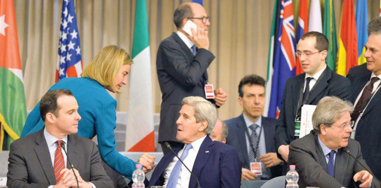 منسقة السياسة الخارجية بالاتحاد الأوروبي فيديريكا موغيريني تحيي كيري على هامش اجتماع التحالف الدولي ضد «داعش» في روما أمس (أ.ف.ب)