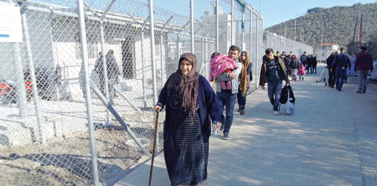 لاجئون في مخيم تحت التأسيس بجزيرة ليزفوس اليونانية لتستقبل العشرات الذين يصلون يوميا من سوريا والعراق وأفغانستان (إ.ب.أ)