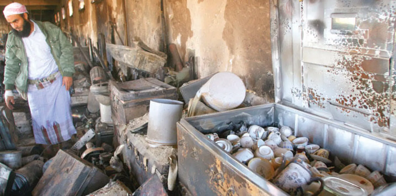 مقاتل من المقاومة الشعبية يتفحص الدمار الذي حل بالمتحف الوطني بتعز (رويترز)