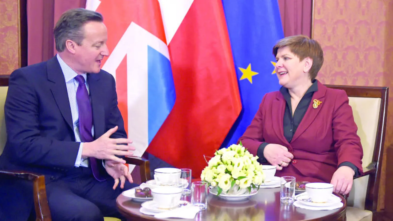 رئيس الوزراء البريطاني ديفيد كاميرون يتحدّث مع نظيرته البولندية بيتا سيدلو في وارسو أمس (أ.ف.ب)