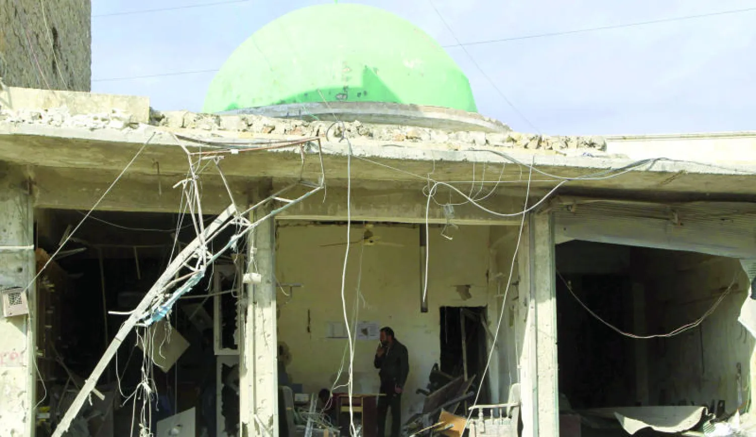 سوري يفحص آثار الدمار الناتج عن قصف طائرات النظام لبلدة شخور بالقرب من حلب أمس (رويترز)