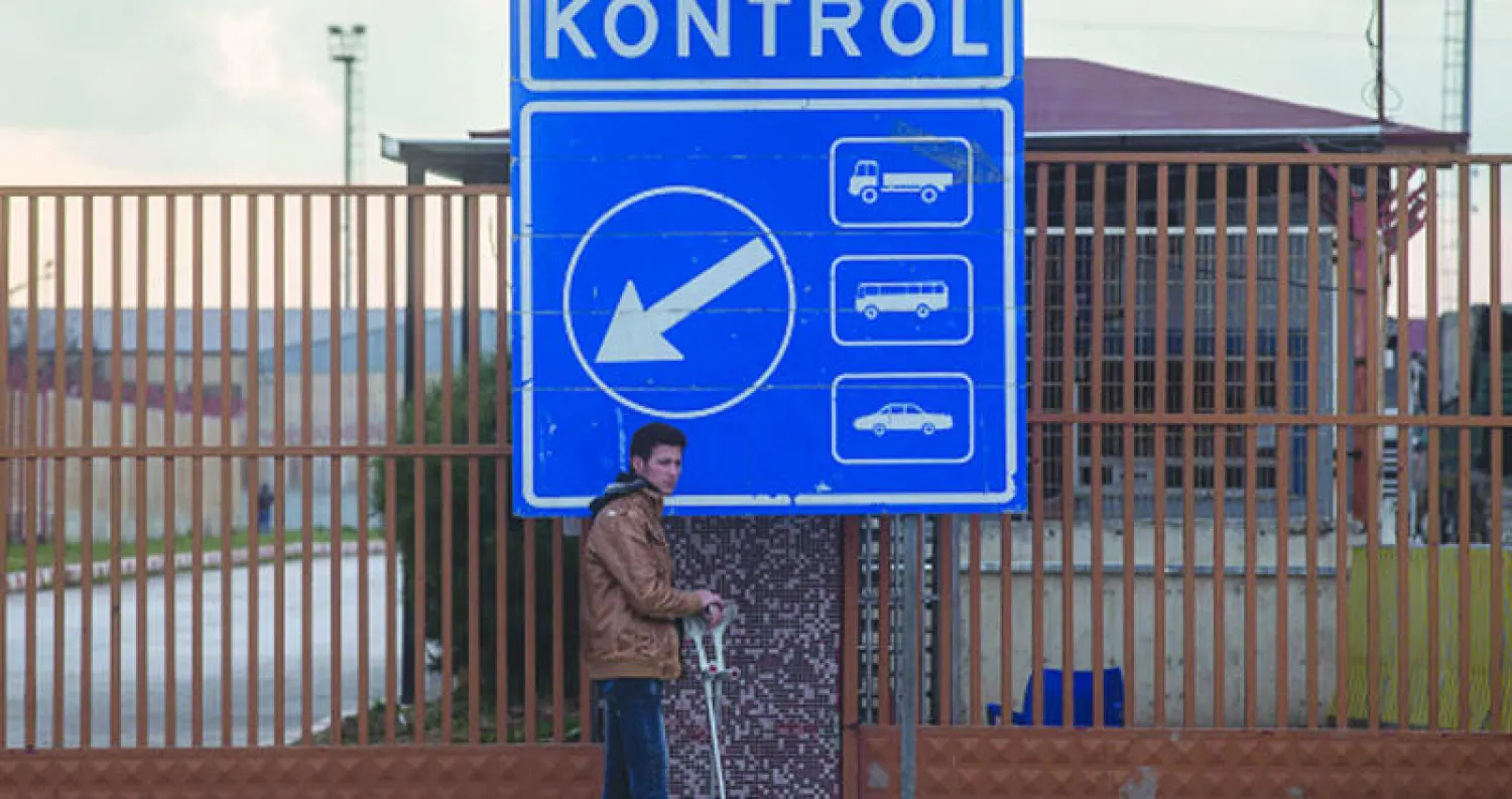 سوري هارب من القصف في مدينة حلب ومحيطها يقف أمام بوابة معبر «باب السلامة» الحدودي بانتظار سماح السلطات التركية له بالعبور (غيتي)