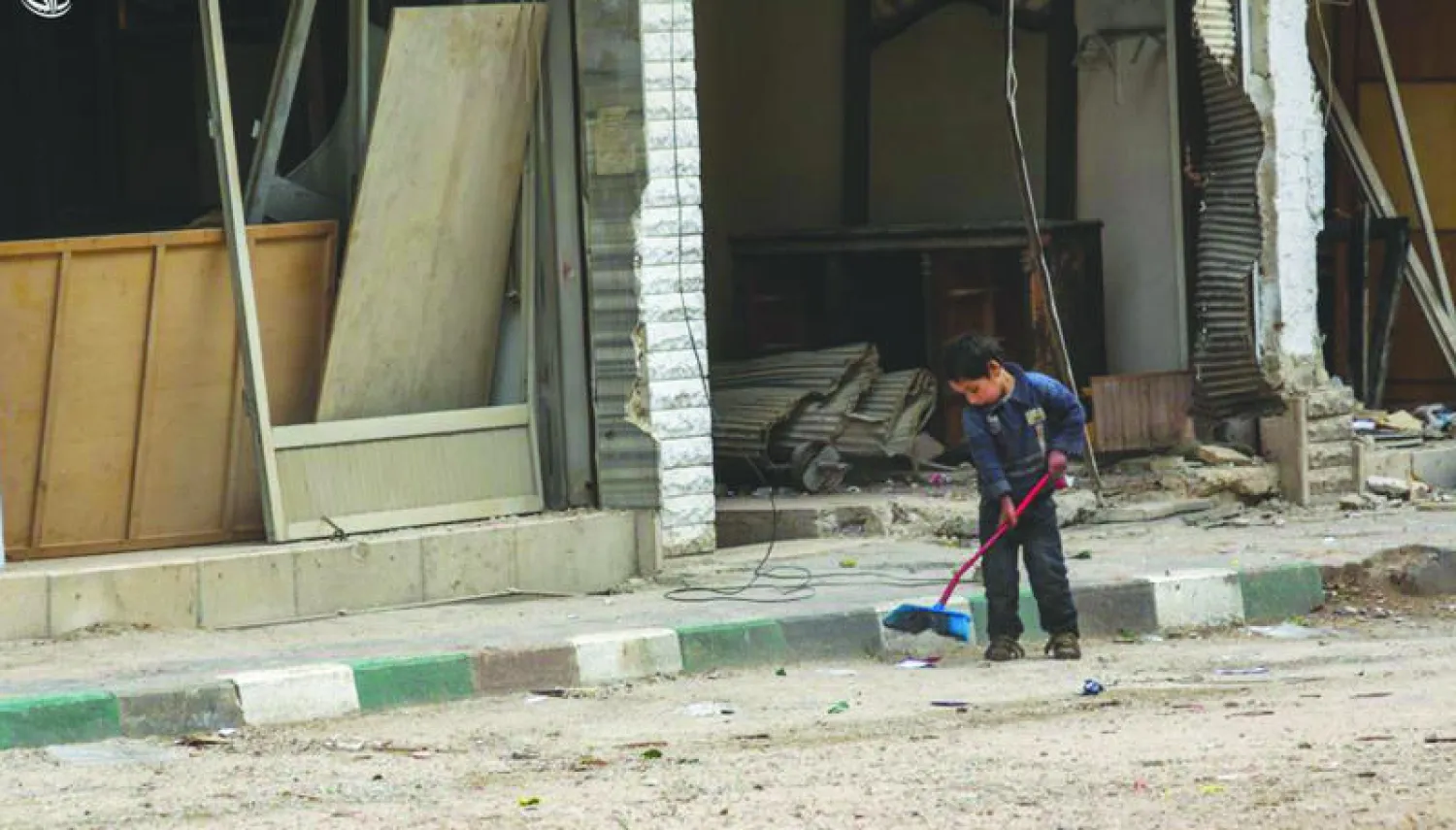 طفل من داريا بريف دمشق يحاول تنظيف الشارع من ركام القصف (المجلس المحلي لمدينة داريا)