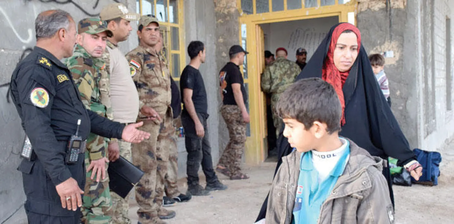 قوات أمن عراقية تشرف على إجلاء مبنى في الرمادي من سكانه أثناء عملية إعادة السيطرة على المدينة (إ.ب.أ)