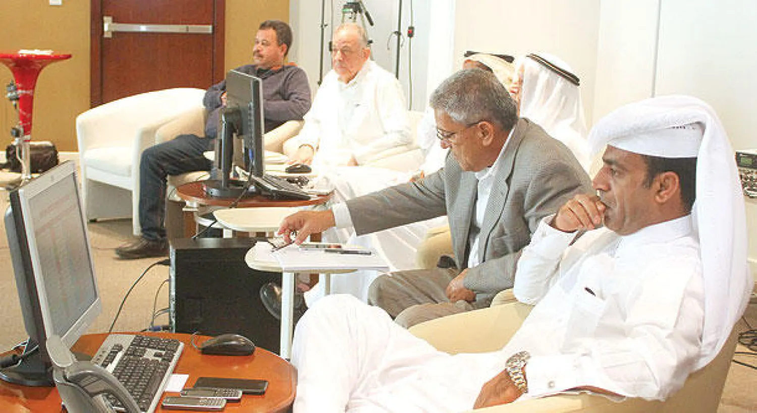 متعاملون يراقبون أسعار الأسهم في سوق الدوحة للأوراق المالية (رويترز)