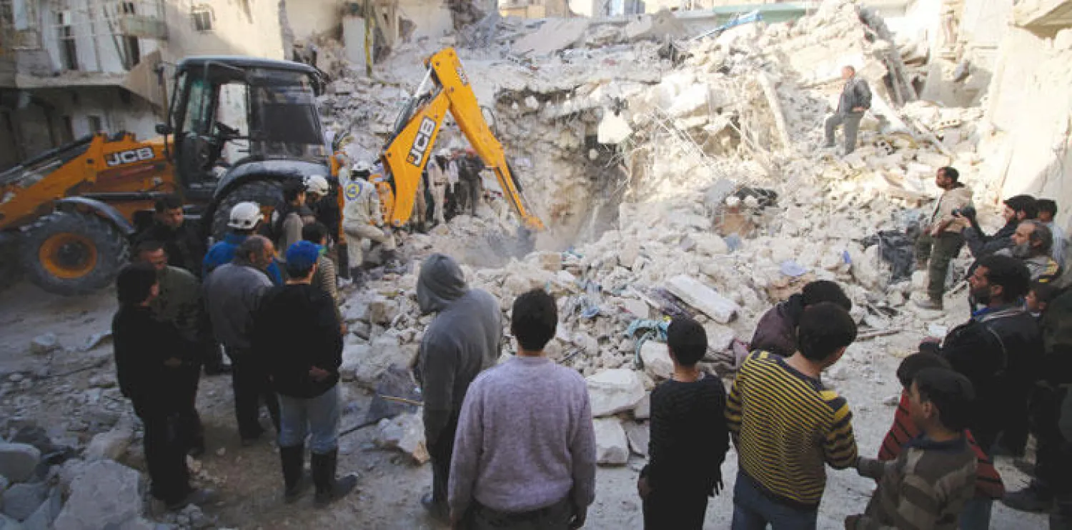 قوات الدفاع الوطني في مدينة حلب تبحث عن ناجين بين الأنقاض بعد قصف الطيران الروسي لحي القاطرجي أمس (رويترز)