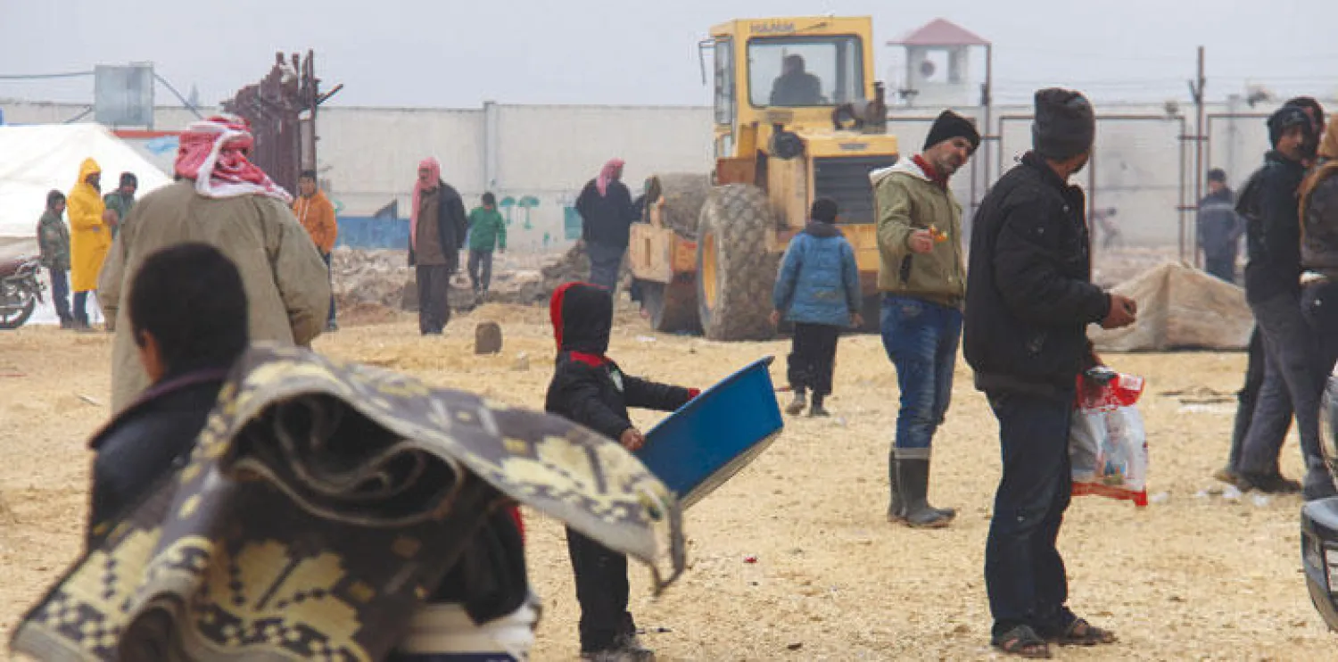 نازحون سوريون هربا من المعارك في ريف حلب الشمالي يتجمعون أمام مخيم باب السلامة قرب الحدود التركية (أ.ف.ب)