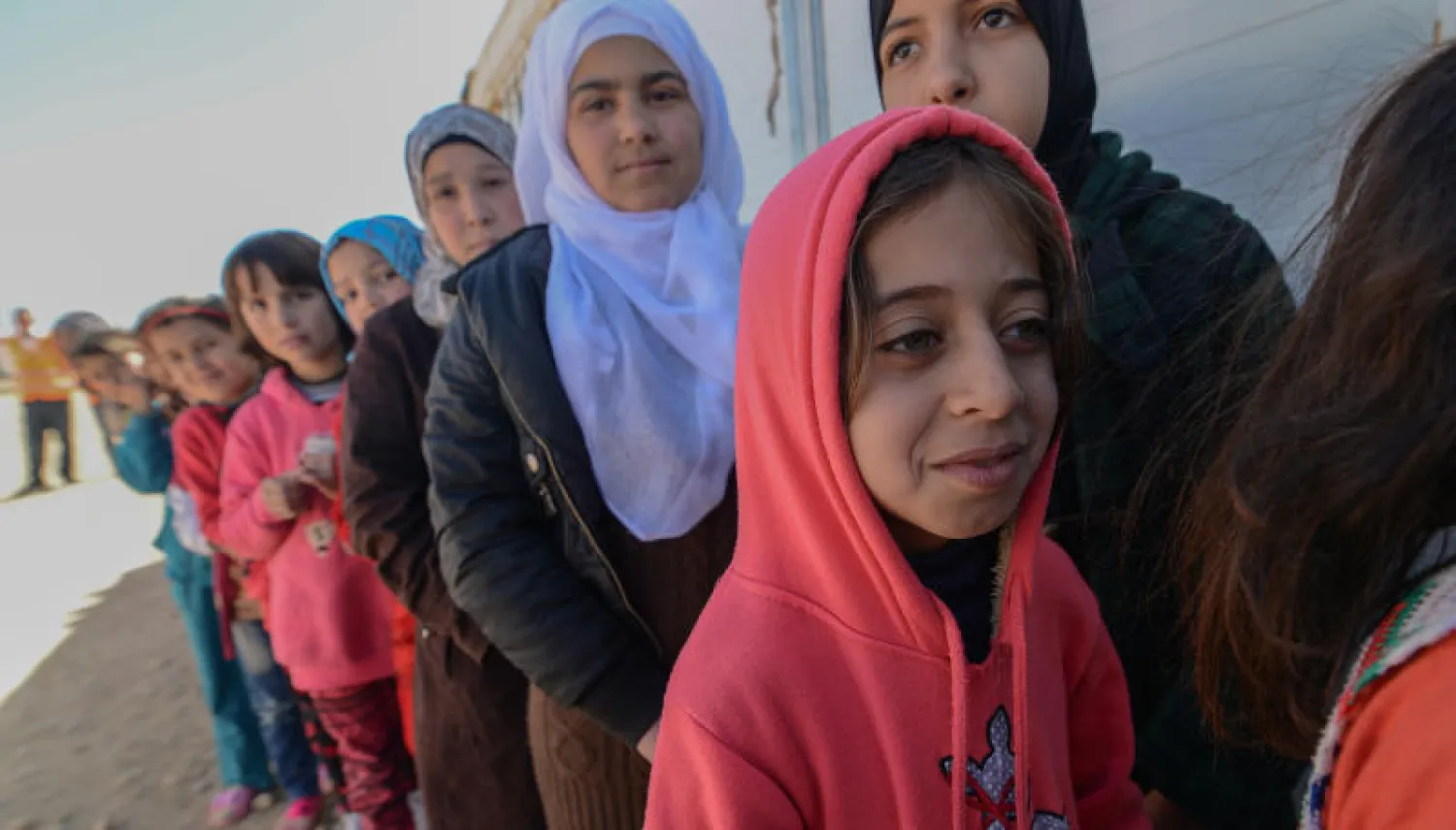 طالبات سوريات ينتظرن دورهن لأخذ المواد الدراسية وبعض الألعاب الترفيهية