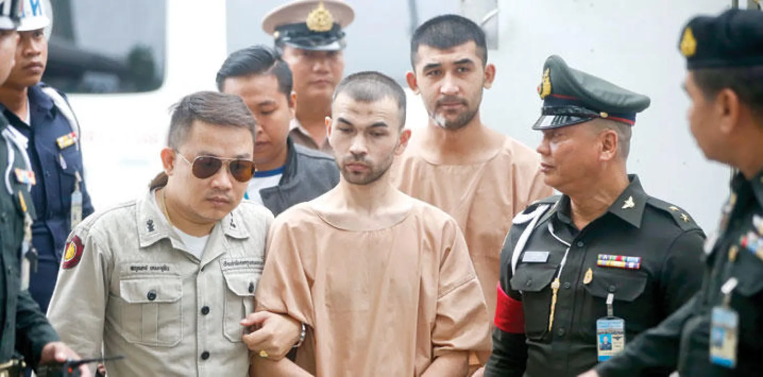 المتهمان بلال محمد الذي عرف باسم آدم قره داغ أيضا وخلفه يوسفو ميرايلي وهما مقيدان قبل مثولهما أمام المحكمة العسكرية في بانكوك أمس (إ.ب.أ)