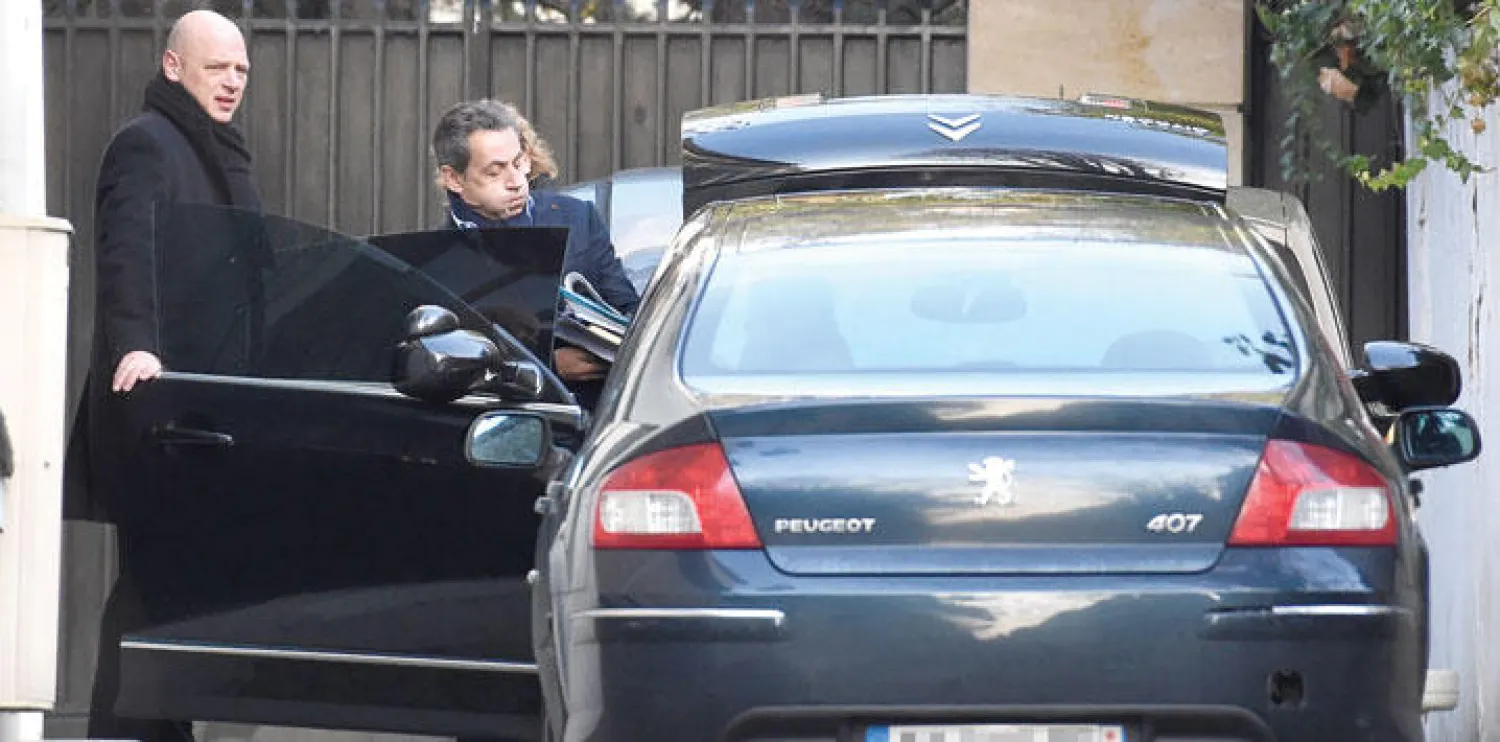 الرئيس الفرنسي السابق نيكولا ساركوزي يهم بركوب سيارته في طريقه إلى مكتبه في باريس أول من أمس (أ.ف.ب)
