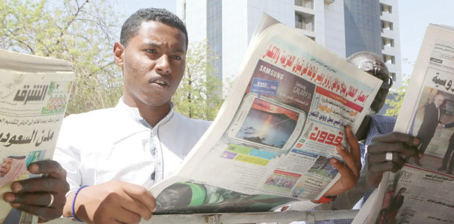سوداني يتابع إحدى صحف بلاده في العاصمة الخرطوم أمس (أ.ف.ب)
