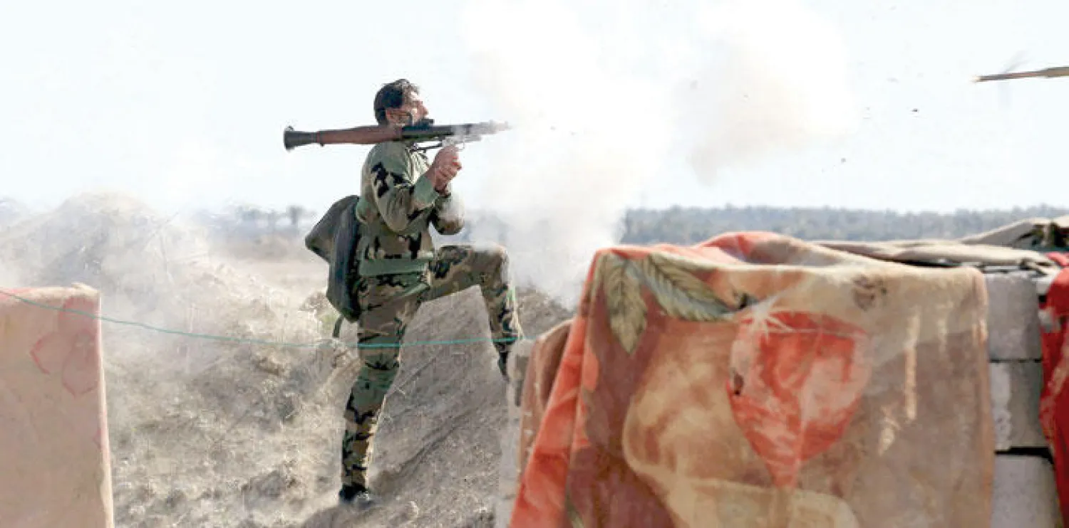 جندي عراقي يوجه سلاحه نحو تواجد عناصر {داعش} غرب مدينة الفلوجة (رويترز)