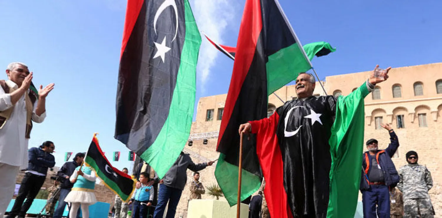 مواطن يلف جسده بخريطة ليبيا خلال احتفالات الليبيين داخل ساحة الشهيد في مدينة طرابلس أمس بذكرى مرور خمس سنوات على اندلاع الثورة (أ.ف.ب)