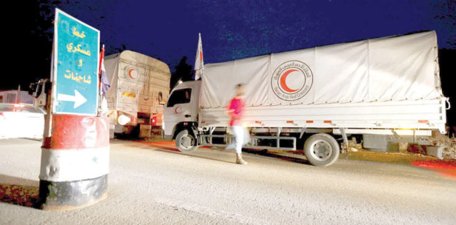 قوافل الهلال الأحمر السوري تنتظر الدخول إلى بلدة مضايا المحاصرة، أمس، بعد زيارة المبعوث الدولي دي ميستورا إلى سوريا، الاثنين، واتفاقه مع حكومة الأسد على دخول المساعدات إلى سبع مناطق محاصرة (رويترز)