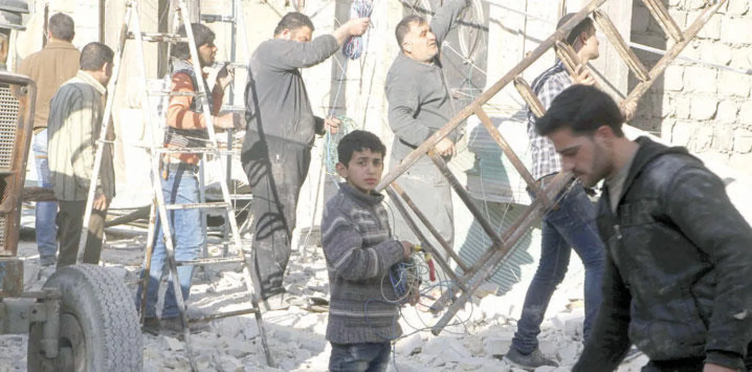 سكان حي الفردوس في مدينة حلب شمال سوريا يحاولون إصلاح ما تم تدميره في أعقاب غارة جوية لقوات النظام أمس (رويترز)