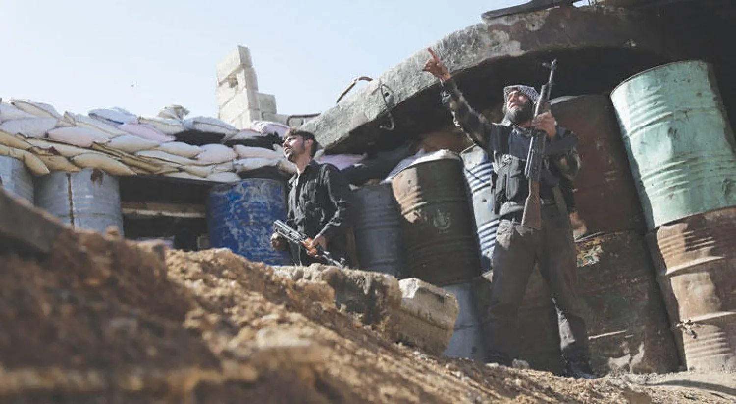 مقاتلان من مجموعة فيلق الرحمن الإسلامية يراقبان أمس تحركات عناصر النظام في مدينة عربين في الغوطة الشرقية بريف دمشق (أ.ف.ب)