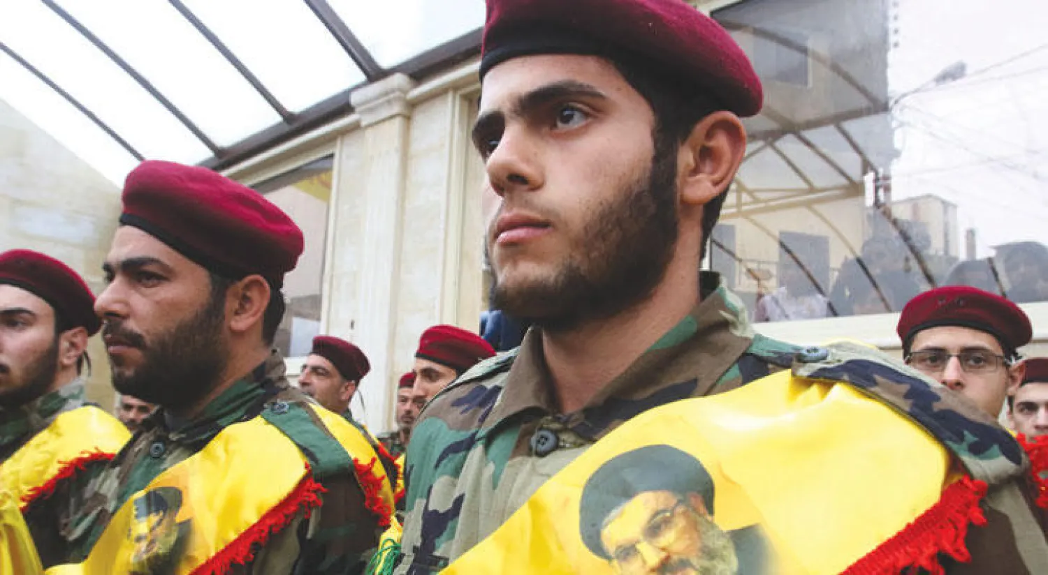 شبان من أتباع حزب الله خلال حضورهم جنازة علي أحمد صبرا الذي قتل في معارك سوريا (أ.ف.ب)