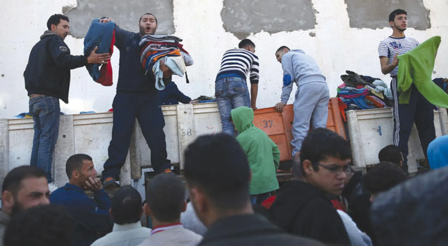 غزاويون يحاولون التغلب على الوضع الاقتصادي الصعب في سوق الأسبوع في القطاع (أ.ف.ب)