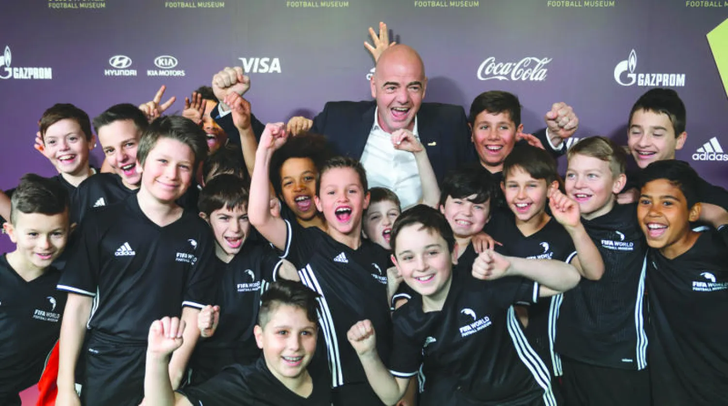 إينفانتينو رئيس «فيفا» الجديد مع تلاميذ مدرسة كرة قدم خلال افتتاح متحف الاتحاد الدولي أمس (أ.ف.ب)