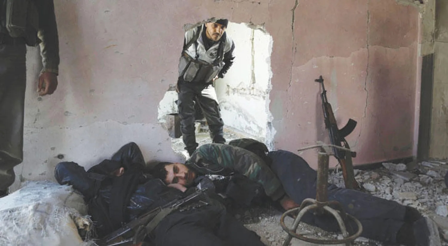 عناصر من «لواء فيلق الرحمن» المعارض في لحظة استراحة داخل مبنى على الخطوط الأمامية في بلدة بالا في الغوطة الشرقية لدمشق (أ.ف.ب)