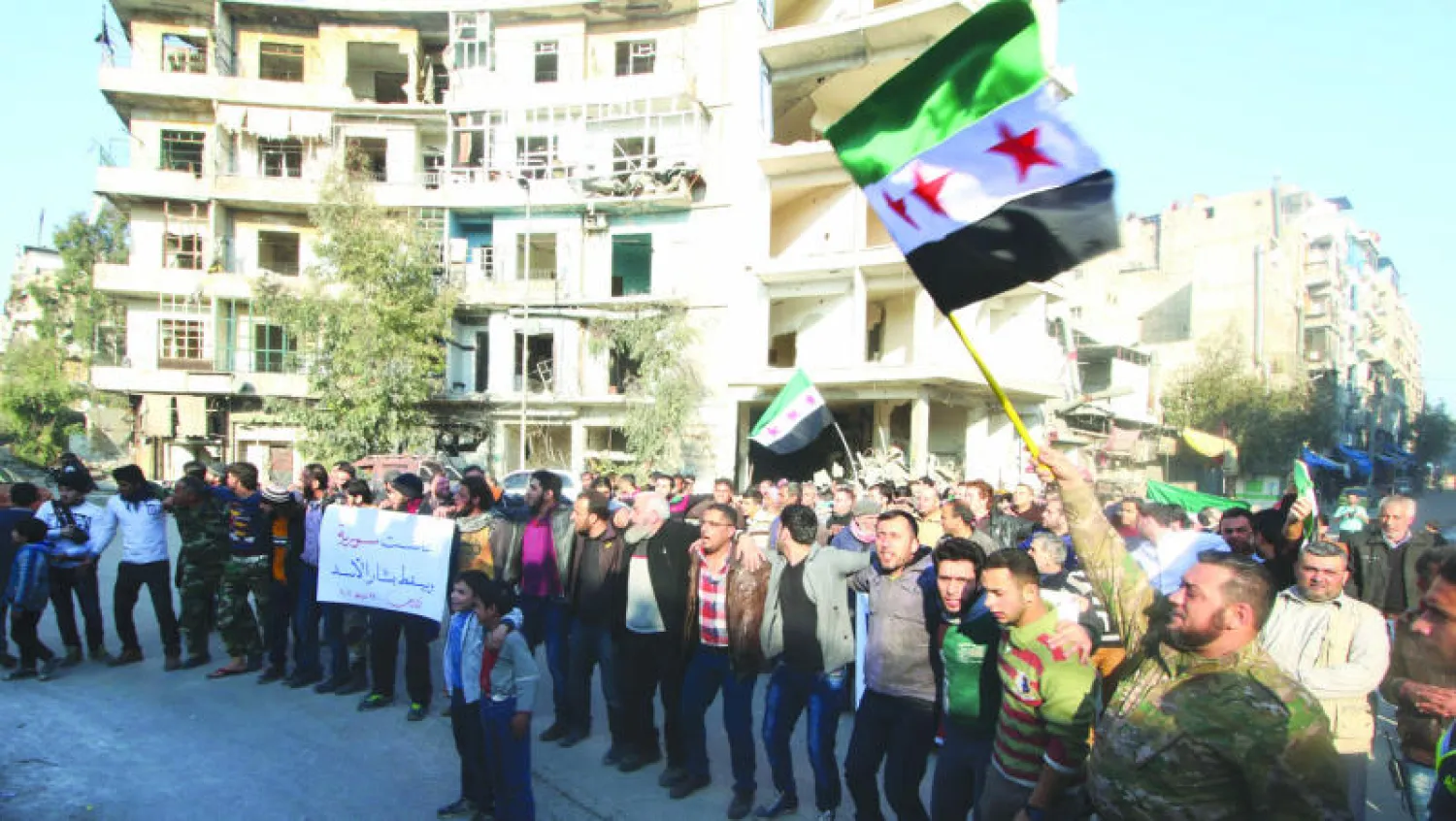 متظاهرون في القسم الذي تسيطر عليه المعارضة في مدينة حلب، امس، حيث رفعوا علم الجيش الحر ونددوا بقوات النظام (رويترز)