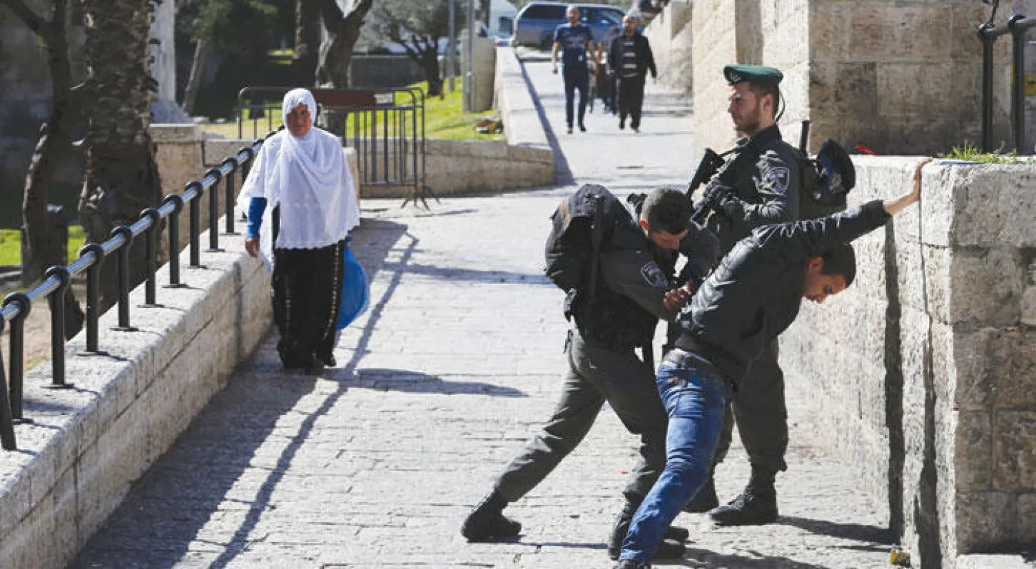أحد جنود الاحتلال يقوم بتفتيش شاب فلسطيني بطريقة عنيفة أمام بوابة دمشق في القدس القديمة (رويترز)