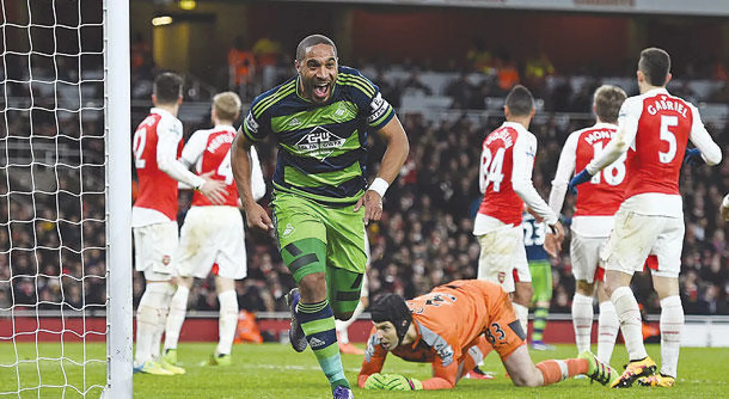 آشلي وليامز قائد سوانزي يحتفل بهدفه في مرمى آرسنال (رويترز)