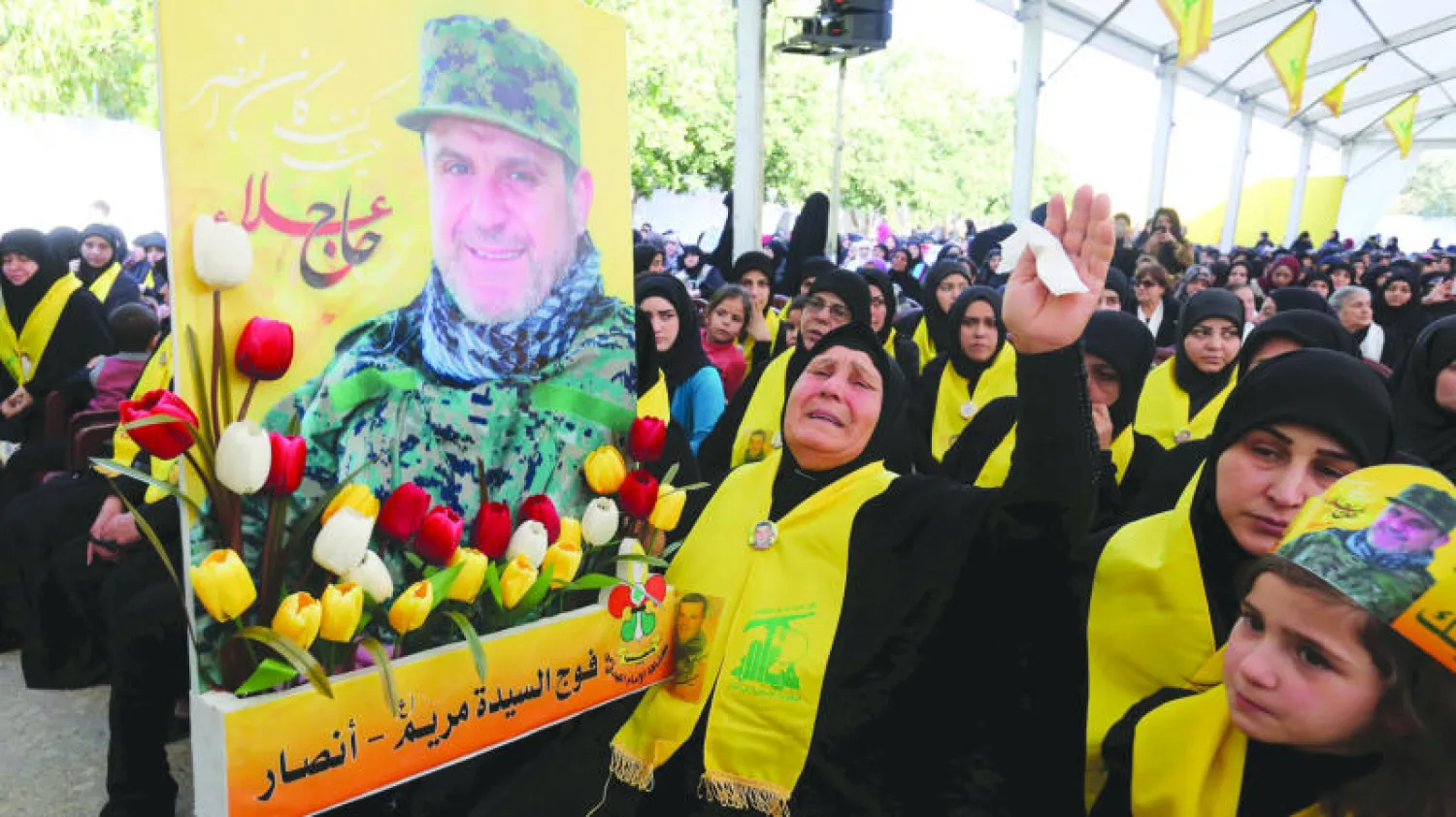 والدة القيادي بحزب الله علي فياض الذي قتل في سوريا تحمل صورته خلال تشييع جنازته في جنوب لبنان أمس (رويترز)